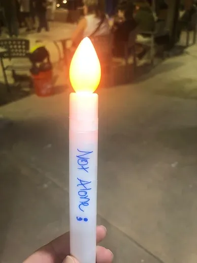 candle that says not alone on it